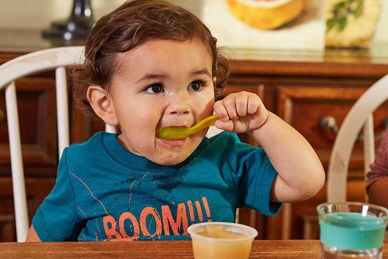 toddler self feeding applesauce
